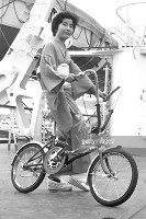 promotional photo of traditionally dressed japanese woman on porta cycle england 1965